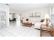 Spacious living area with neutral décor and tile floors, open to the dining area for easy entertaining at 9330 Migue Cir, Port Charlotte, FL 33981
