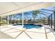 Relax in the screened-in pool area overlooking the waterway, complete with a sun shelf and seating at 9330 Migue Cir, Port Charlotte, FL 33981