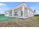 A modern home with a covered patio transitions from patio to the lush green lawn at 10447 New Brunswick St, Port Charlotte, FL 33981
