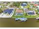 A canal-front home with a pool, boat dock, and lush green landscaping at 10640 Ayear Rd, Port Charlotte, FL 33981