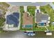 Aerial view of home featuring a screened-in pool, boat dock, and well manicured lawn at 10640 Ayear Rd, Port Charlotte, FL 33981