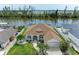 Waterfront home featuring a beautiful lawn, tropical landscaping, and convenient dock with boat lift at 10640 Ayear Rd, Port Charlotte, FL 33981