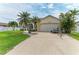 Well-manicured home featuring a lush lawn, mature landscaping, and an attached two-car garage at 10640 Ayear Rd, Port Charlotte, FL 33981