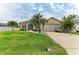 Well-maintained home with a manicured lawn, mature palm trees, and an attached two-car garage at 10640 Ayear Rd, Port Charlotte, FL 33981