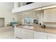 Bright kitchen with breakfast bar open to living room and view of pool area at 10640 Ayear Rd, Port Charlotte, FL 33981