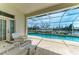 Outdoor patio with a screened-in pool, furniture, and scenic waterfront views at 10640 Ayear Rd, Port Charlotte, FL 33981