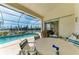 Outdoor patio with a screened-in pool, furniture, and scenic waterfront views at 10640 Ayear Rd, Port Charlotte, FL 33981