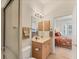 Bathroom featuring a walk-in shower and a sink with cabinets. Bedroom can be seen through the doorway at 1104 Yosemite Dr, Englewood, FL 34223