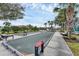 Community bocce ball court with seating, landscaping, and a view of a pond at 1104 Yosemite Dr, Englewood, FL 34223