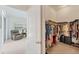Open walk-in closet featuring ample clothing racks and shelving, plus a view of the living room at 1104 Yosemite Dr, Englewood, FL 34223
