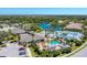 Aerial view of a community clubhouse, pool, tennis courts and lake surrounded by trees and other homes at 1104 Yosemite Dr, Englewood, FL 34223
