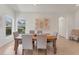 Well-lit dining room with beige tile floor, wooden table with six chairs, and neutral wall colors at 1104 Yosemite Dr, Englewood, FL 34223