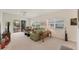Cozy living room featuring plush seating, neutral tones, and a sliding glass door leading to the screened-in patio at 1104 Yosemite Dr, Englewood, FL 34223