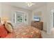 Bedroom with a large window, TV on a dresser, ceiling fan, and a floral bedspread at 1104 Yosemite Dr, Englewood, FL 34223