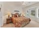 Cozy bedroom with a floral bedspread, two bedside tables, and a bright bay window at 1104 Yosemite Dr, Englewood, FL 34223