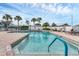Community pool featuring clear blue water and ample seating surrounded by palm trees at 1104 Yosemite Dr, Englewood, FL 34223