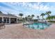 A community pool featuring clear blue water and ample seating surrounded by palm trees at 1104 Yosemite Dr, Englewood, FL 34223