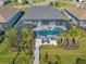 Aerial view showcasing the home's pool, screened lanai, landscaping, and private dock at 14564 Gaspar Loop, Port Charlotte, FL 33981