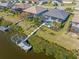 Overhead photo of a waterfront backyard with a dock, screened in pool, and lush vegetation at 14564 Gaspar Loop, Port Charlotte, FL 33981