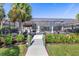 Beautiful backyard with a screened lanai, pool, tiki bar, and lush tropical landscaping at 14564 Gaspar Loop, Port Charlotte, FL 33981