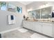Bright bathroom with granite countertops, double sinks, and a large mirror at 14564 Gaspar Loop, Port Charlotte, FL 33981
