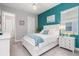 Bright bedroom features coastal decor, a plush white bed, and an accent wall at 14564 Gaspar Loop, Port Charlotte, FL 33981