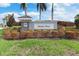 Entrance sign for Harbor West community amid well-maintained landscaping and tall palm trees at 14564 Gaspar Loop, Port Charlotte, FL 33981
