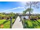 Scenic waterfront view of a wooden dock extending into a tranquil canal under a clear blue sky at 14564 Gaspar Loop, Port Charlotte, FL 33981