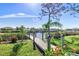 Scenic waterfront view of a wooden dock extending into a tranquil canal under a clear blue sky at 14564 Gaspar Loop, Port Charlotte, FL 33981