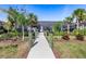 Wooden dock leading to a screened-in lanai and outdoor seating area, surrounded by lush landscaping at 14564 Gaspar Loop, Port Charlotte, FL 33981
