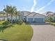 Stunning home featuring a three-car garage, tile roof, and meticulously landscaped front yard at 14564 Gaspar Loop, Port Charlotte, FL 33981