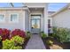 Charming home entrance with double glass doors, elegant landscaping, and a brick pathway at 14564 Gaspar Loop, Port Charlotte, FL 33981
