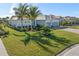 Beautifully landscaped front yard with lush green lawn and mature palm trees at 14564 Gaspar Loop, Port Charlotte, FL 33981