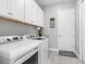 Functional laundry room featuring modern washer/dryer, white cabinets, and sleek flooring at 14564 Gaspar Loop, Port Charlotte, FL 33981