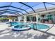 Enjoy the Florida sunshine in this enclosed pool area featuring a spa and comfortable seating at 14564 Gaspar Loop, Port Charlotte, FL 33981