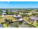 Aerial view showcases waterfront home with pool, boat dock, and lush landscaping in a desirable community at 14810 Ingraham Blvd, Port Charlotte, FL 33981