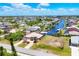 Breathtaking aerial view of a coastal community featuring waterfront homes along canals under a partly cloudy sky at 14810 Ingraham Blvd, Port Charlotte, FL 33981
