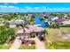 Stunning waterfront home boasts a three-car garage, a tile roof, and lush landscaping with mature palm trees at 14810 Ingraham Blvd, Port Charlotte, FL 33981