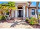 Elegant front entrance with stately columns, a brick walkway, and lush landscaping framing the doorway at 14810 Ingraham Blvd, Port Charlotte, FL 33981
