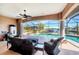 Enclosed patio overlooking a pool and canal with comfortable seating and a ceiling fan at 14810 Ingraham Blvd, Port Charlotte, FL 33981