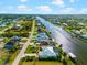 Aerial view shows a waterfront property with a private pool and canal access in a residential neighborhood at 15380 Alsask Cir, Port Charlotte, FL 33981