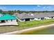 Homes with gray roofs are by a tranquil pond and lush lawns, showcasing modern community living at 1607 Laurel Brook Ln, Port Charlotte, FL 33953