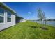 Lush backyard featuring well-manicured lawn, scenic lake view, and newly planted tree at 1607 Laurel Brook Ln, Port Charlotte, FL 33953
