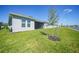 Spacious backyard showcasing a serene lake view, verdant lawn, and a young, newly planted tree at 1607 Laurel Brook Ln, Port Charlotte, FL 33953