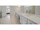 Bright bathroom featuring double sinks with white countertops and a glass-enclosed shower at 1607 Laurel Brook Ln, Port Charlotte, FL 33953