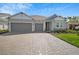 Beautiful one-story home featuring a 3-car garage and a charming brick driveway at 1607 Laurel Brook Ln, Port Charlotte, FL 33953
