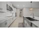 This modern kitchen features white cabinets, an island, stainless steel appliances, and tile flooring at 1607 Laurel Brook Ln, Port Charlotte, FL 33953