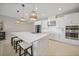 A sleek, all-white kitchen features stainless appliances, tile backsplash, and a large island with bar seating at 1607 Laurel Brook Ln, Port Charlotte, FL 33953
