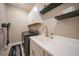 Functional laundry room with modern washer and dryer, overhead cabinets, sink, and stylish decor at 1607 Laurel Brook Ln, Port Charlotte, FL 33953