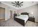 Spacious bedroom with a dark wood bed, carpeting, a ceiling fan and an ensuite bathroom at 1607 Laurel Brook Ln, Port Charlotte, FL 33953
